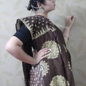 Close-up of brown cotton saree featuring white shell and wooden bead tassels on the pallu.